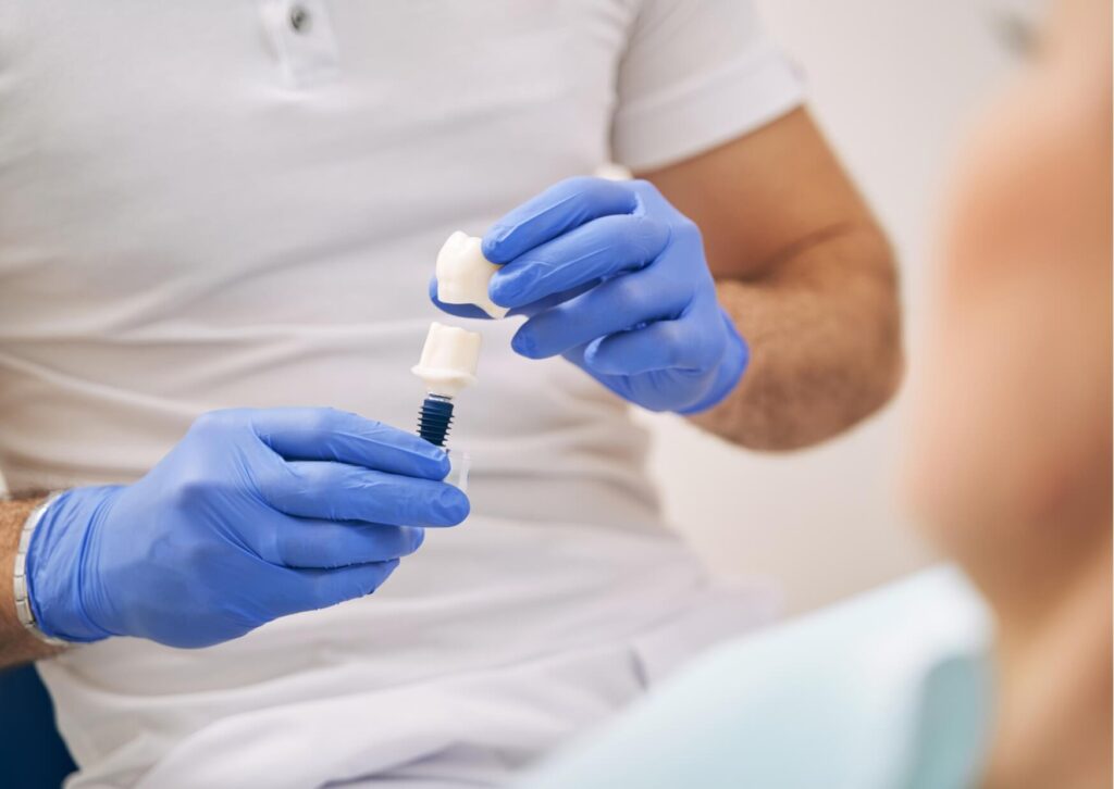 Dentist explaining the components of a dental implant to a patient during a consultation about long-term implant durability.
